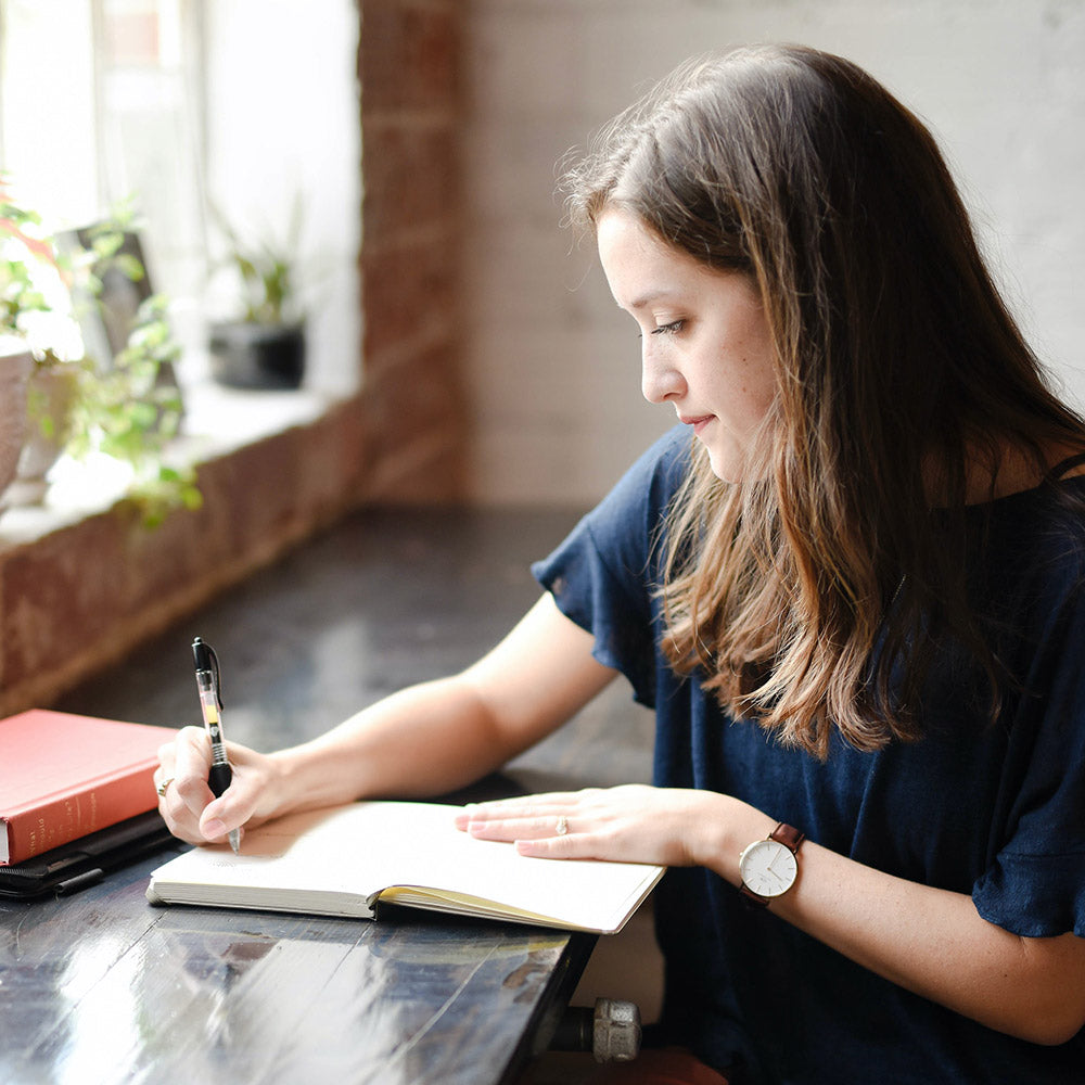 woman writing in journal for life coaching services
